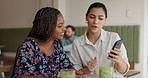 Cafe, friends and women with smartphone, talking and showing healthy diet on social media and smile. Restaurant, laughing and people with smoothies for nutrition, conversation and browsing on mobile
