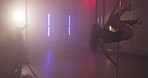 Women, dancing and pole in studio with neon lights, choreography and practice show. Burlesque, people and exotic dancer group at mirror for performance, spinning and smoke for aesthetic in spotlight