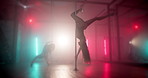Women, dancing and pole in studio with neon lights, balance skill or practice routine. Burlesque, people or exotic dancer group on stage for performance, nightlife or smoke for aesthetic in spotlight