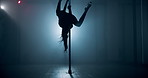 Woman, exotic dancing and pole with spin, stage and creativity with balance for concert event in dark. Person, dancer and movement with swivel, performance and flexible for fantasy at nightclub