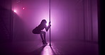 Woman, silhouette and dancing with pole on stage for exotic bend, private performance or show in spotlight. Nightclub, performer and seductive routine with purple neon, sensual movement and burlesque