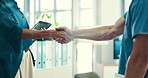 Shaking hands, doctors and meeting with tablet at hospital, closeup and welcome with introduction. People, handshake and hiring for medical career with success, achievement and touchscreen at clinic