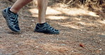 Walking, sneakers and man with fitness, hiking and nature with weekend break, hobby and recreation. Legs, closeup and person in park, steps and exercise with health, wellness and cardio with workout