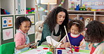 Painting, teacher and children with artwork, talking and creativity in classroom, growth and development. Happy, woman and teaching kids in preschool, learning and education for youth with color