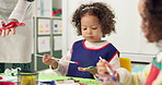 Child, student and painting hand in classroom with creative lesson, drawing picture and kindergarten learning. Kids, brush and messy with fun activity, artwork project and motor growth for education