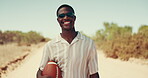 Desert, face and road trip with black man outdoor for break, travel or vacation at sandy destination. Adventure, journey or relax and happy tourist person in nature with ball for getaway or holiday
