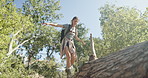 Happy woman, walking and log with balance for hiking adventure, trail or extreme trail in nature. Female person, hiker or journey with smile or backpack on tree for trekking path in forest or woods