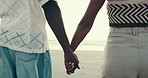 Beach, holding hands and couple with love, vacation and anniversary with relationship. Closeup, people or man with woman, seaside or ocean with marriage, travel or romance with summer holiday or care