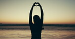 Heart hands, silhouette and woman at beach for sunset, love symbol or icon for care, freedom and calm. Nature, back of person and travel with gesture or sign for wellness, emoji and sea holiday