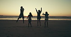 Jump, friends and people on beach at sunset for holiday, summer vacation and adventure together. Nature, travel and back of men and women by sea, ocean and waves for freedom, happy and fun on weekend
