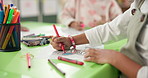 Person, hands and child with drawing for coloring, fun activity or assessment at kindergarten school. Closeup, kid or learner with paper or pencil for fine motor skills or early childhood development