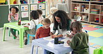 Woman, teacher and helping children in kindergarten classroom for early childhood development. Female person, educator or instructor with kids or drawing for youth, fun activity or coloring at school