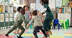 Teacher, children and holding hands in circle for playing, jumping game and fun activity in recess. Montessori, people and learning break for classroom community, motor skills and growth development