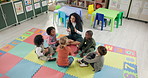 Woman, teacher and learning with kids above in nursery for activity, education or listening skills at kindergarten. Female person, educator or instructor with children in sing along, class or school
