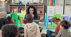Woman, teacher and reading with book or children in nursery for story time, education or learning. Female person, educator or instructor with elementary kids or novel for listening activity in class