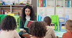 Reading, classroom and teacher with children at school for development, growth or fantasy book. Happy, lesson and female educator with storytelling for kid students for learning at kindergarten.