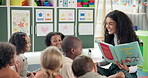 Woman, teacher and reading book with elementary kids in nursery for story time, education or learning. Female person, educator or instructor with children or novel for listening activity in classroom