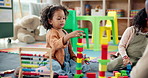 Child, student and play with blocks in class for learning, problem solving and creative activity. Excited, girl and building fail with education game, puzzle solution and motor growth in kindergarden