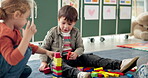 Children, student and play with blocks in class for learning, problem solving and creative activity. Kids, toys and building stack for education game, puzzle solution and motor growth in kindergarden