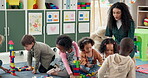 Teacher, children and play with blocks in class for learning, problem solving and creative activity. Woman, kids and building toys for education game, puzzle solution and motor growth in kindergarden