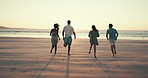 Running, friends and back of people on beach at sunset for holiday, summer vacation and adventure together. Nature, travel and men and women by sea, ocean and waves for freedom, happy and weekend