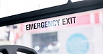 Bus, sign and window with emergency exit for safety, evacuation and information on commute. Public transport, travel and glass for escape, security and words with caution or warning in empty vehicle