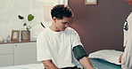 Doctor, woman and man with blood pressure check for hypertension, circulation and assessment at hospital. People, medic and patient with test, cardiology and services for wellness on bed at clinic