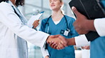 Handshake, meeting or doctors in hospital with closeup for introduction, appointment or health treatment. Nurses, teamwork or people shaking hands for medical advice, greeting and clinic research