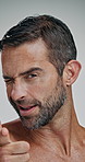 Man, skincare and finger gun in studio with face, playful and smile for flirt, sign and confident by background. Mature person, model and hand gesture with wink, happy and cosmetic results in Turkey