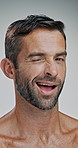 Glow, face and man with smooth skin, studio and skincare with cosmetics for beauty and wellness. White background, aesthetic and person with treatment for shine, dermatology and wink in Canada