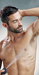 Happy man, spray or deodorant with hygiene for scent, aroma or cologne on a studio background. Male person, antiperspirant or model applying perfume with smile for armpit, odor mask or body fragrance