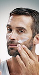 Mature man, face or skincare with cosmetics in studio for facial treatment on a white background. Portrait, male person or model applying moisturizer with cream, lotion or protection for smooth skin