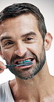 Mature man, face and brushing teeth with toothbrush in studio for dental care on a white background. Portrait, male person or model with smile or cleaning tool for oral hygiene, fresh breath or gums
