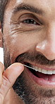 Happy man, teeth and face with dental floss in studio for oral care, hygiene or cavity on a white background. Portrait, male person or closeup of model with smile or string for cleaning gums or mouth