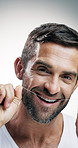 Mature, happy man or face with dental floss in studio for oral care, hygiene or cavity on a white background. Portrait, male person or model with smile, string or wire for clean teeth or fresh breath