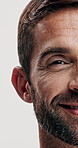 Half, face and man for beauty with skincare, beard or facial hair for grooming, smile and cosmetic care on white background. Happy, antiaging for skin and closeup portrait for dermatology in studio