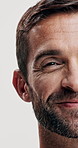 Half, face and man for beauty with skin, beard or facial hair for grooming, smile and cosmetic care on white background. Happy, antiaging skincare and closeup portrait for dermatology in studio