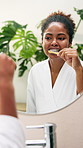 Happy, black woman and cleaning teeth with mirror in bathroom for dental care or hygiene at home. Female person, brushing or bamboo toothbrush with reflection for fresh breath or morning routine