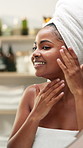 Happy, black woman and skincare with mirror in bathroom for moisturizer, morning routine or cosmetology. Female person, smile or face cream with towel for hygiene or facial treatment at home spa