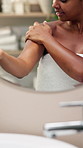 Hands, lotion and shoulder with skincare by mirror in bathroom for smooth texture, wellness and moisturizer. Person, self care and smile for cream, cosmetics and routine for beauty with dermatology