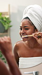 Black woman, cleaning and brushing teeth with mirror in bathroom for dental care or hygiene at home. Female person, oral health or morning routine with reflection for gums or fresh breath at house