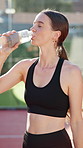 Woman, drinking water and bottle at tennis court for sport, hydration and break in summer for workout. Person, girl and athlete with liquid, rest and tired at training for competition in Portugal
