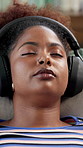Black woman, sleeping or listening with headphones on sofa for relax or online streaming at home. Female person, user or lying asleep with sound app for audio therapy, stress relief or peace at house