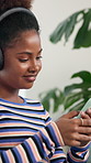 Happy, black woman or listening with headphones to music for audio streaming on sofa at home. Female person, user or sound with smile on mobile smartphone or app for playlist, album or relax at house