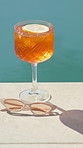 Orange, cocktail and sunglasses with water by pool for hospitality at summer getaway or resort. Empty, drink or cool mocktail with lemon or shades for weekend vacation, party or vitamin C by poolside