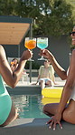 Toast, party and women with cocktail in swimming pool for weekend, break or vacation. Relax, friends and girls in water with smile, drink and alcohol at hotel or lodge resort for summer getaway