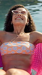 Inflatable, smile and woman with holiday in swimming pool for weekend, break or vacation. Relax, sunglasses or girl in water with fun, travel and rest at hotel or lodge resort for summer getaway