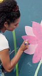 Mural, woman and creative painting on wall for art, flower decoration or student with design outdoor. City, color or artist with brush for culture, diy or back for floral hobby with community project