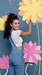 Happy woman, back and artist with wall art for floral design, colorful creativity or community service. Female person, volunteer or outreach with paint or smile for flower, mural activity or charity