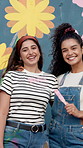 Women, smile and together with painting mural for flowers, art or design for community by wall. Girl, painter and friends with face for social responsibility, excited or volunteer by building in city